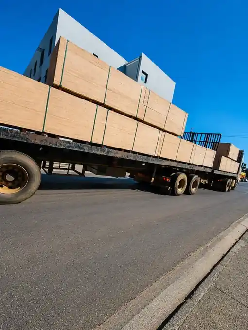 Flatbed truck carrying large shutterply bundles